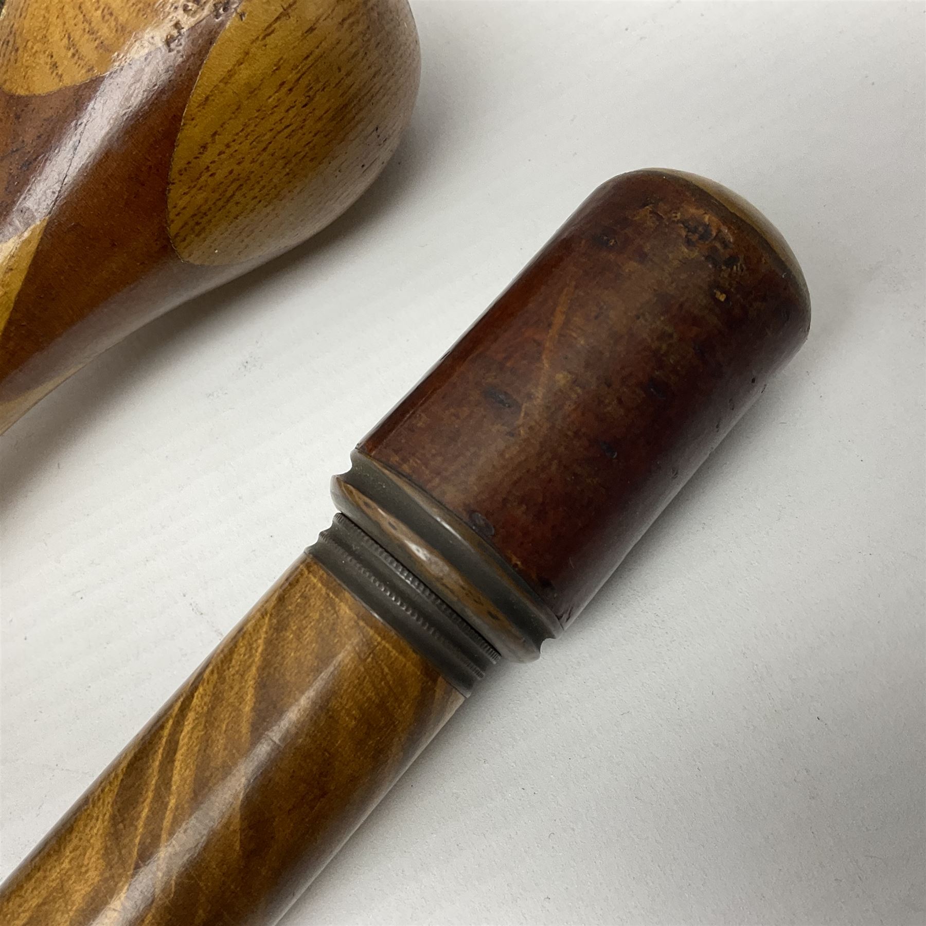 Three early 20th century walking sticks, to include a smoking pipe walking stick, the cane opening to reveal a concealed pipe, and a wooden walking cane, the metal cover with inscription 'bell metal and wood of York Minster, Burnt May 20 1840, and a turned wooden walking stick, with marquetry checkerboard pommel, tallest L90cm