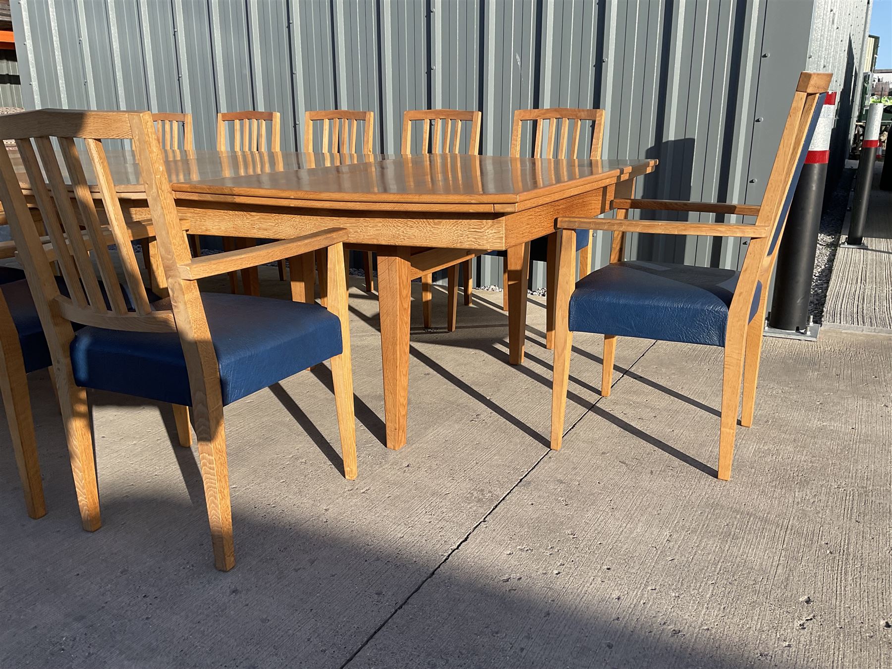 Light oak bespoke boardroom table, concave form, four sectional top on square discreet legs (12' x 5'), with twelve armchairs including 'Chairmans' chair