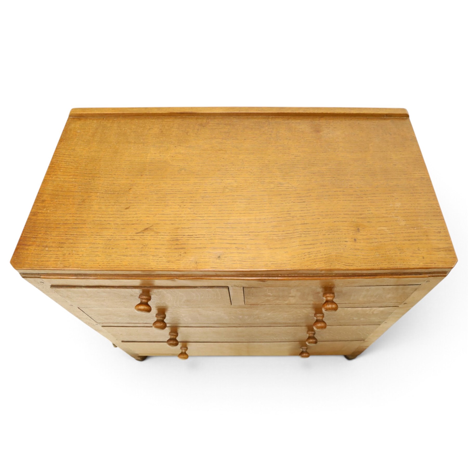 Mouseman - early-to-mid 20th century adzed and panelled oak chest, raised back over rectangular adzed top with canted corners, fitted with two short over three long drawers with turned knob handles, raised on octagonal feet, with carved mouse signature, by the workshop of Robert Thompson of Kilburn