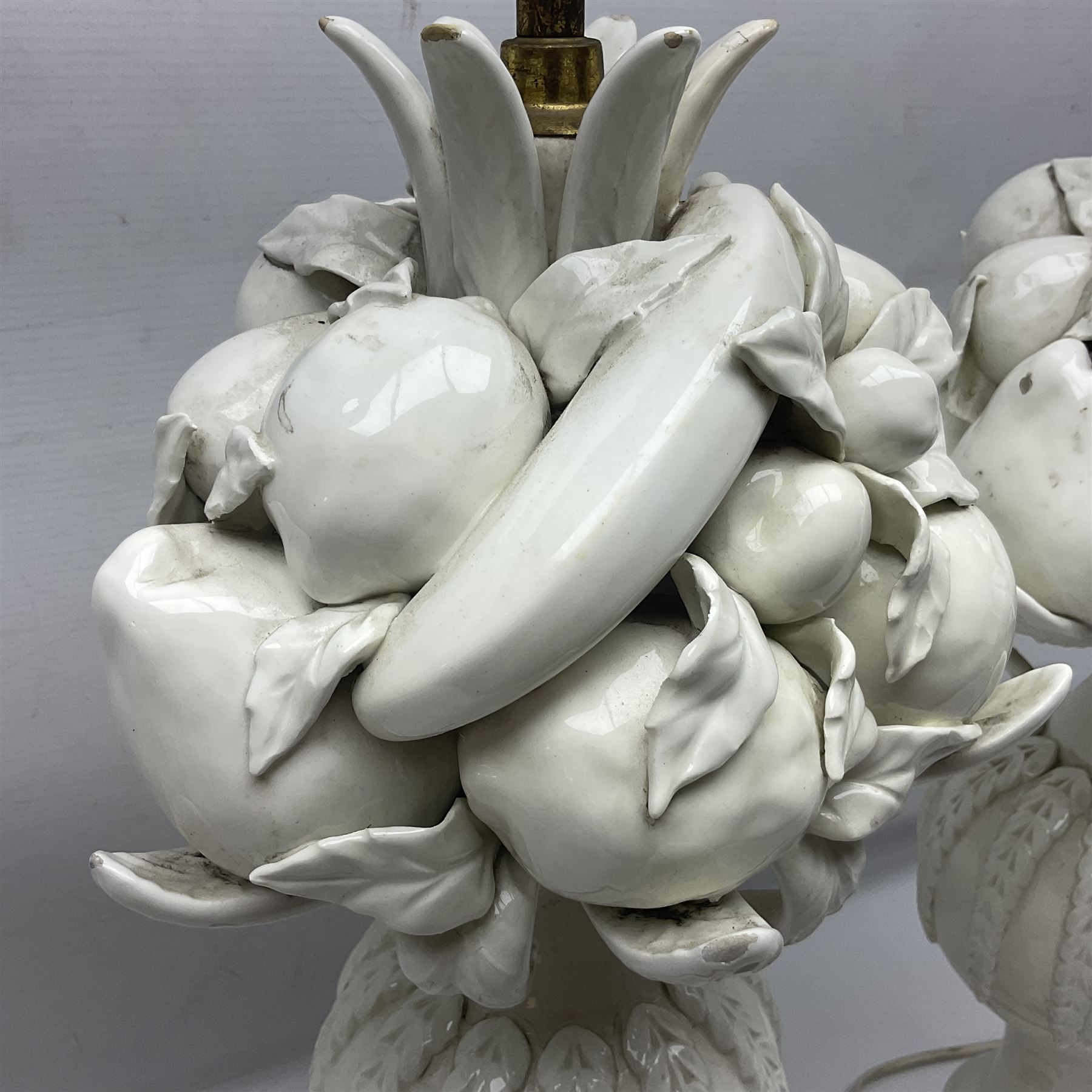 Pair of Casa Pupo white-glazed table lamps, modelled as a fruit upon a column of baluster form with foliate decoration, on a giltwood base, H62cm