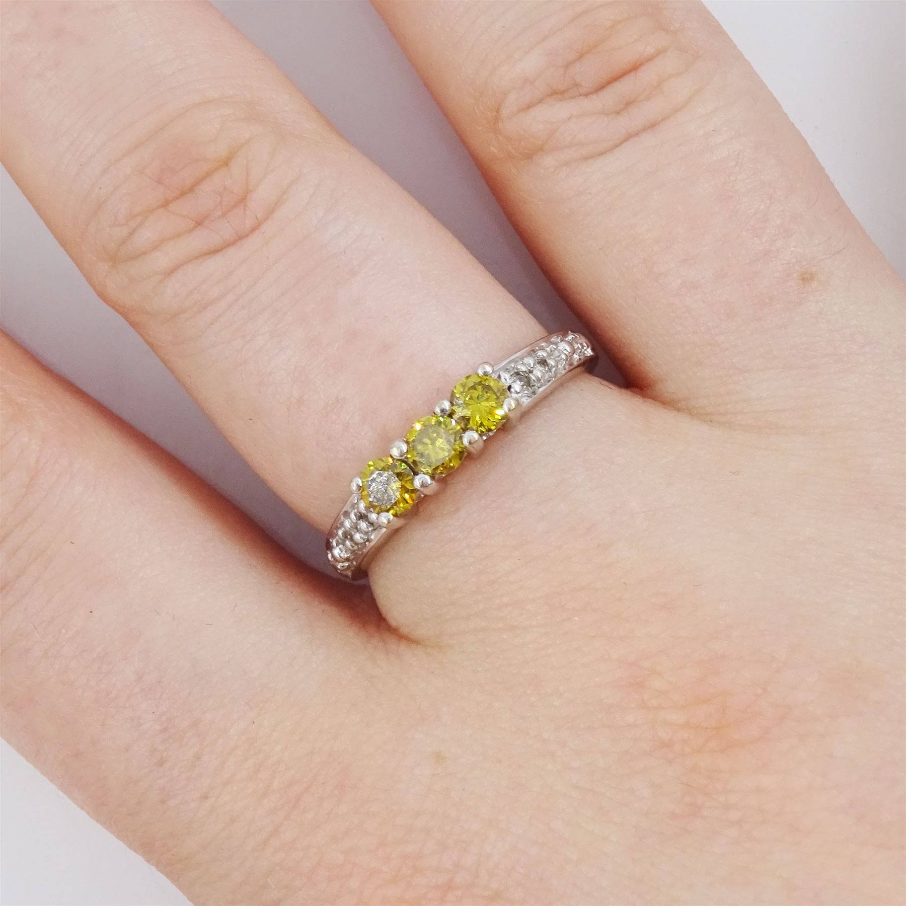 18ct white gold three stone fancy yellow diamond ring, with diamond set shoulders, hallmarked, total yellow diamond weight approx 0.40 carat