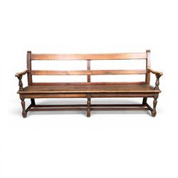 Early 20th century pine and oak bench seat, stained pine rail back frame with shaped oak arms
