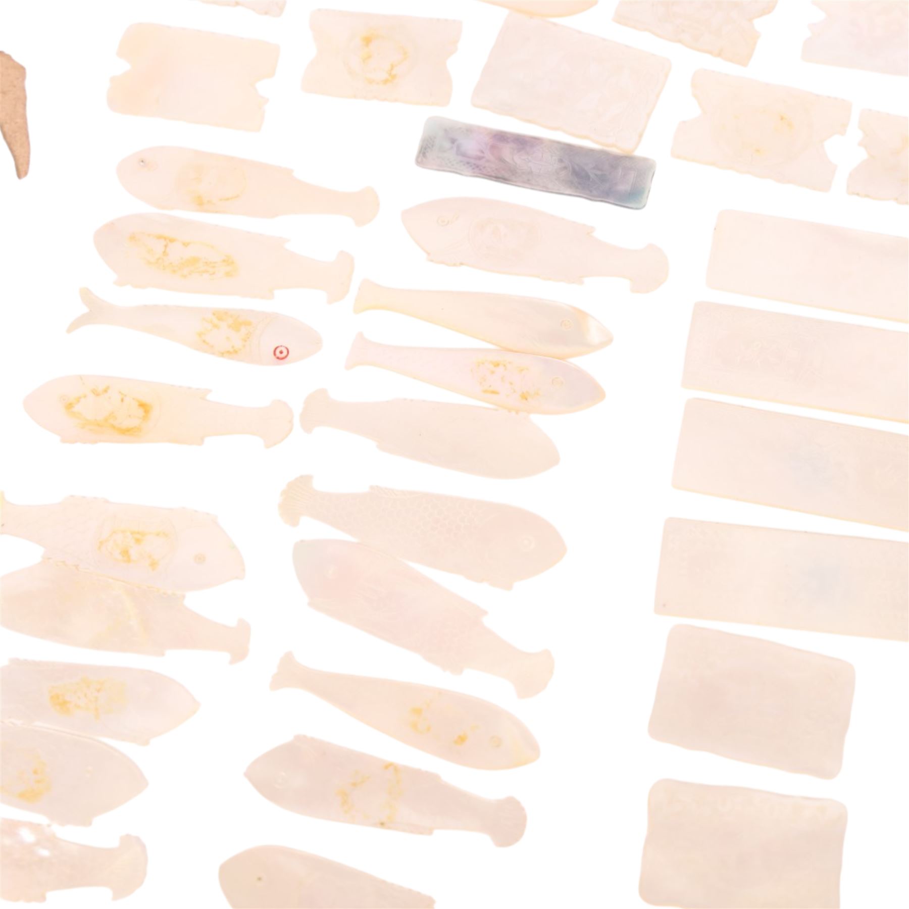 Collection of approximately sixty mother-of-pearl gaming tokens, including fish-shaped, rectangular, circular examples 