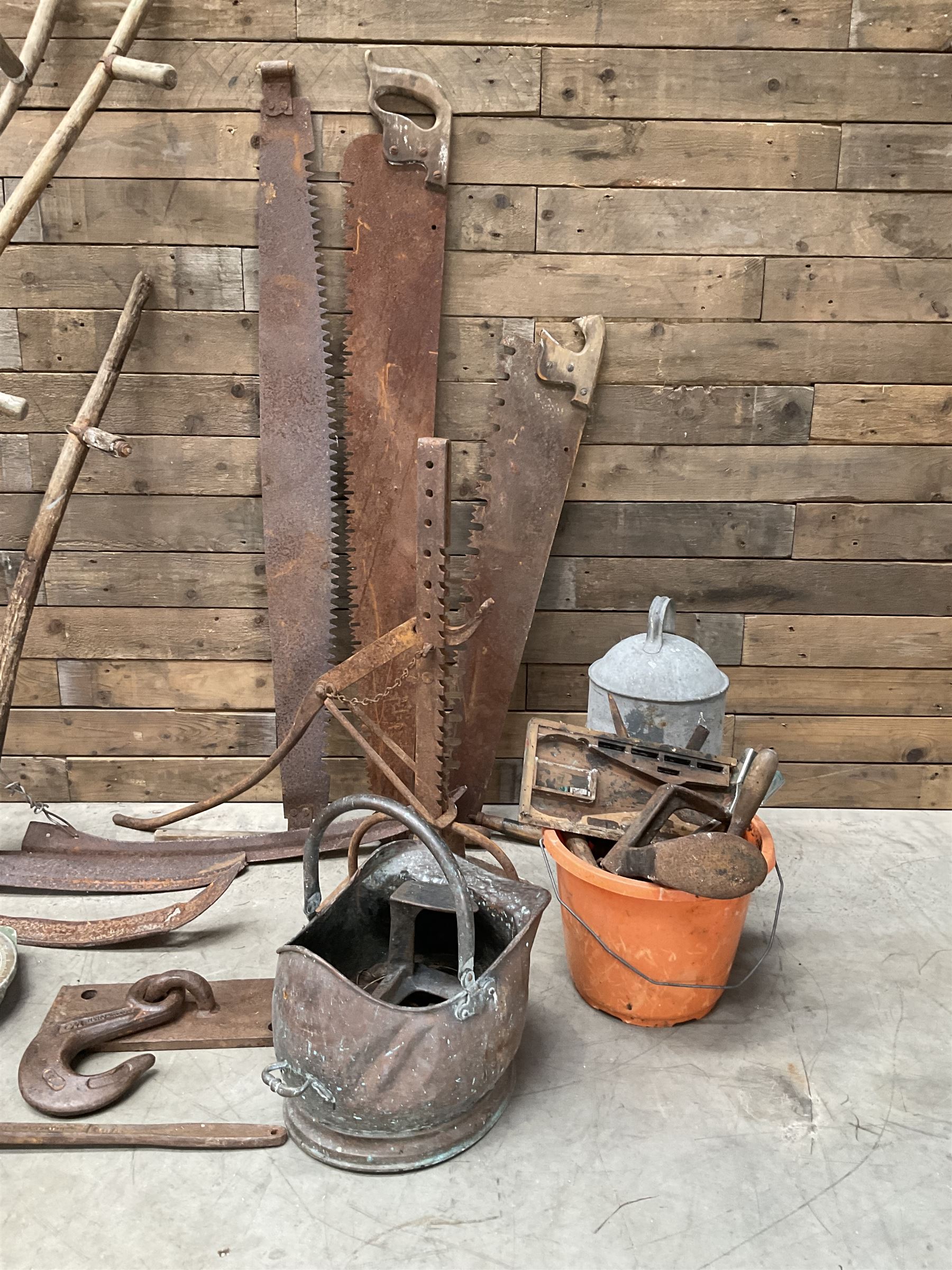 Large quantity of vintage hand tools including scales, scythes, saws etc