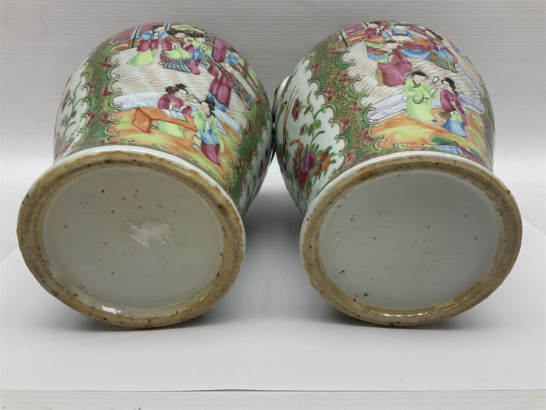 Pair of 19th century Chinese Famille Rose vases and covers, each of baluster form with twin gilt lion mask ring handles to shoulders, the flattened domed covers with gilt temple lion finials, each decorated with alternating reserves of bijin and attendants, and birds and butterflies amongst blossoming peonies, against a gilt ground profusely decorated with stylised scrolls, H32.5cm