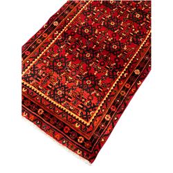 Persian Hamadan red ground runner, the field decorated with Herati motifs, multi-band border decorated with stylised flower heads 