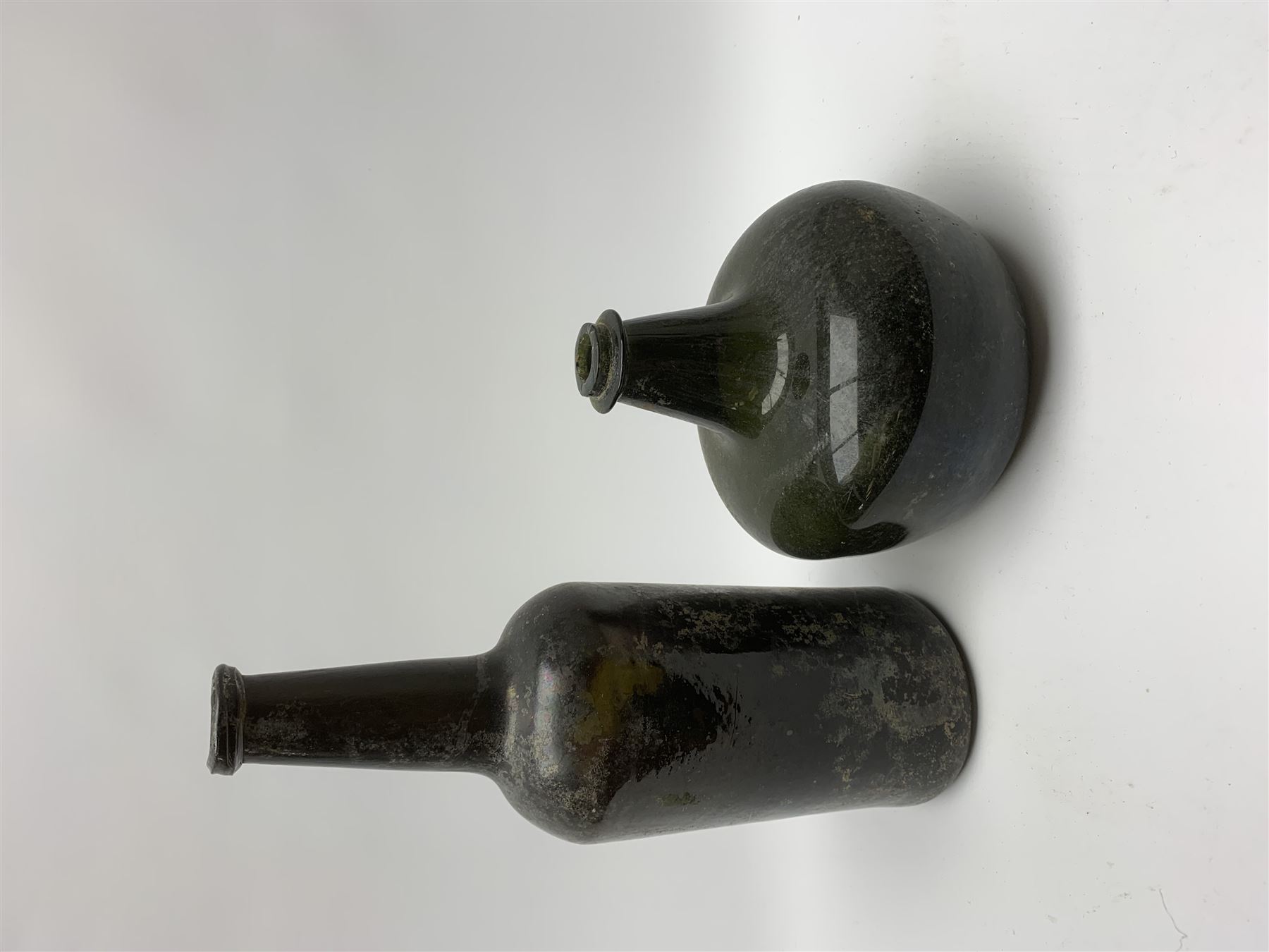 18th century green glass bottle, of onion form, H15cm, together with an 18th century green glass wine bottle, with seal depicting a boar beneath a crown, probably the Edgcumbe Crest, H27cm