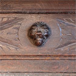 French carved oak cabinet in the Renaissance revival style, cornice carved with scrolling acanthus flanked by lion mask ring terminals, above glazed door with scroll supports over a carved panelled cupboard section with radiating shell motif and geometric quarter panels with foliate ornamentation, raised on a moulded plinth base 