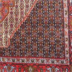 Persian Ardakan rug, featuring central elongated diamond medallion with serrated edges on a repeat boteh field, framed by triple guard borders with red floral scroll design