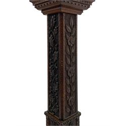 Late 19th century carved oak pedestal torchère stand, stepped and moulded square top carved with foliage, each side carved with trailing foliage with putto or mask, on stepped and moulded base carved with foliate lunettes 
