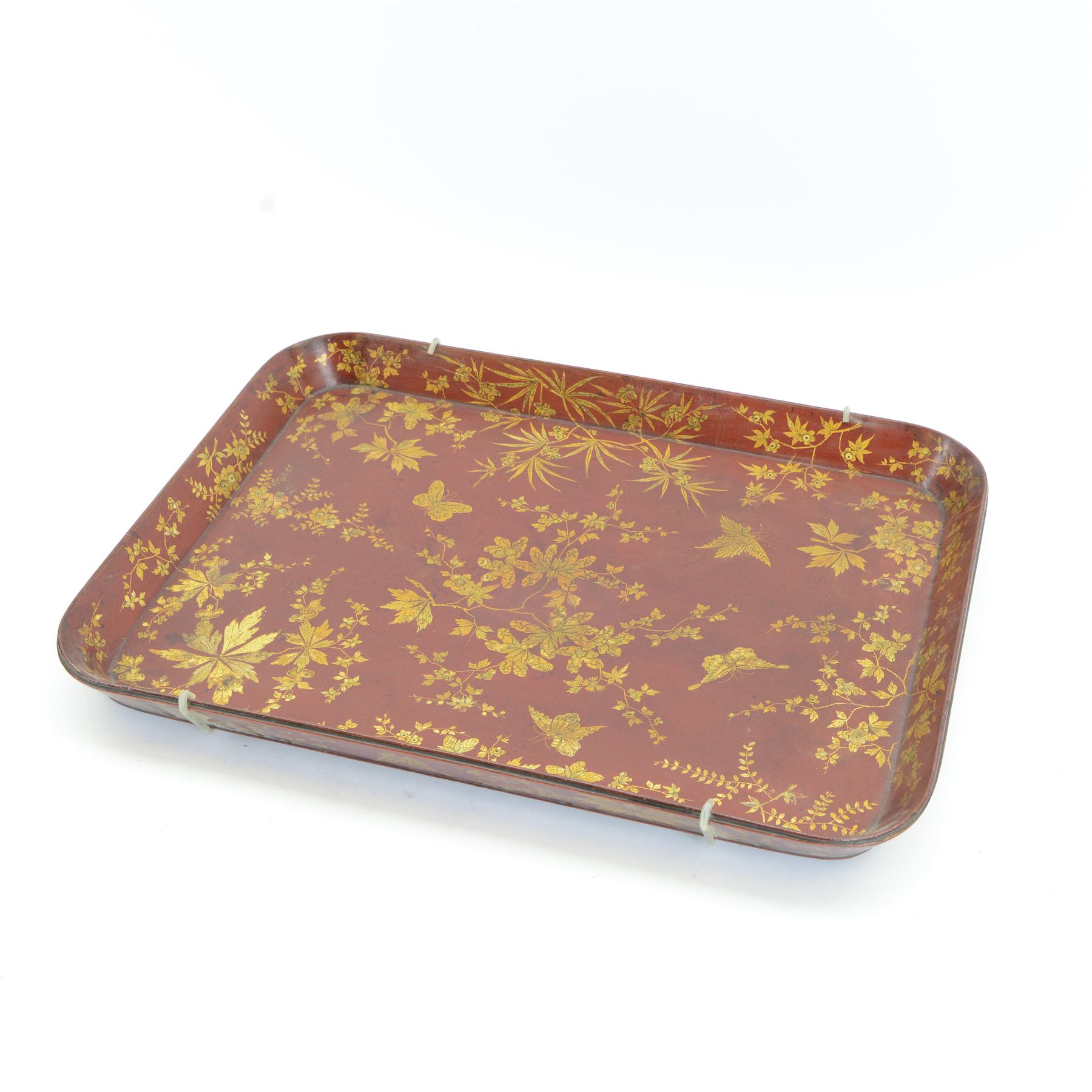 Early 19th century red lacquered papier-mâché tray by Clay of King Street Covent Garden, of rounded rectangular form, painted in gilt with large foliate sprays and butterflies, impressed verso CLAY KING ST COVENT GARDEN, W66.5cm D48.5cm