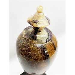 Early 19th century and later Blue John urn, Winnats one vein, of ovoid form with integrated cover and ball finial, upon a spreading circular base, and square stepped black lacquered base, H34.5cm
