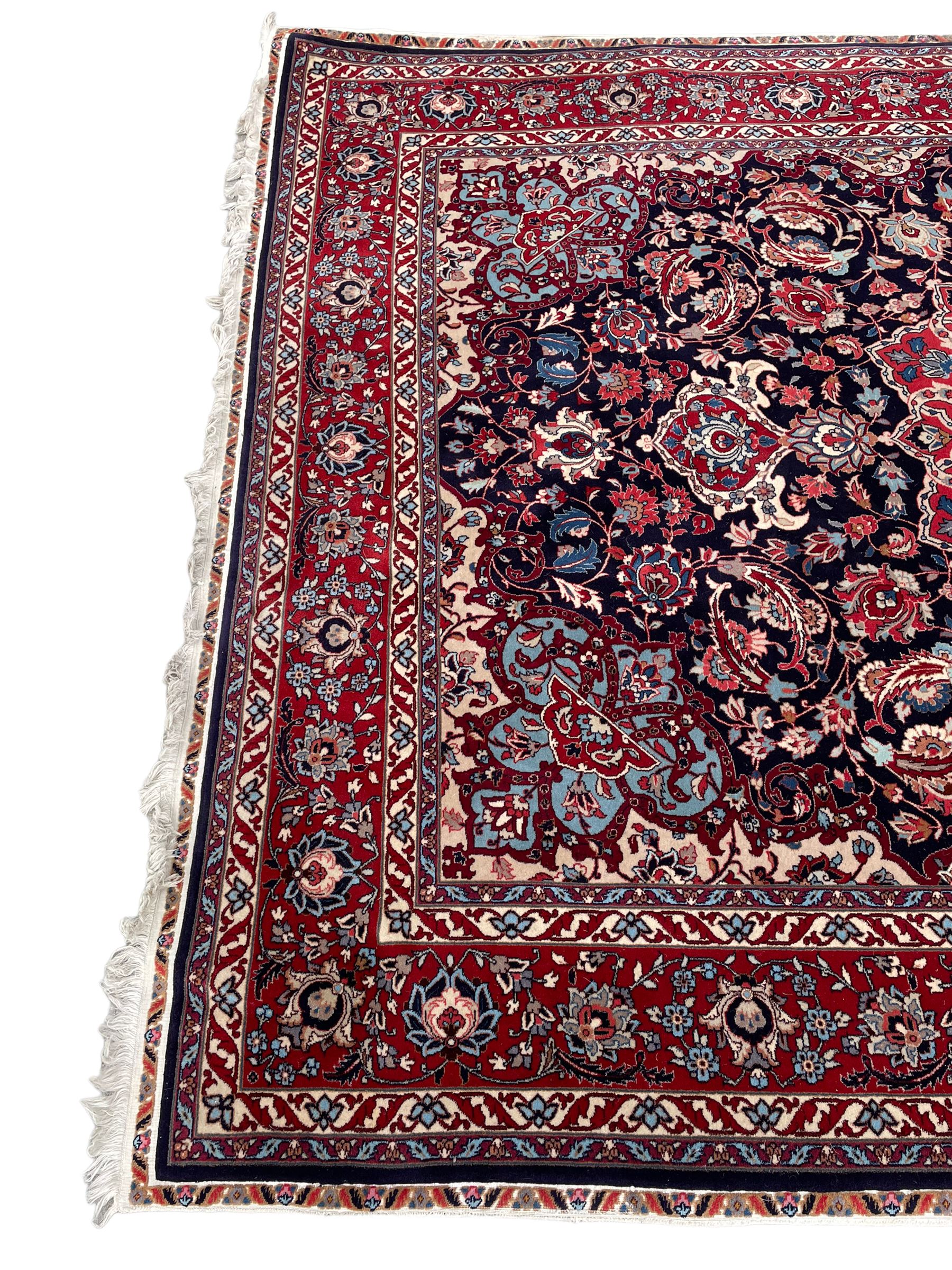 Persian Hamadan indigo ground rug, central floral crimson pole medallion surrounded by trailing foliate decoration and stylised plant motifs, the main guarded border with repeating stylised flower heads, densely knotted