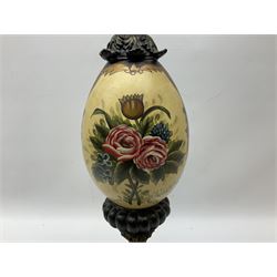 Late 19th/early 20th century table lamp, the ovoid  shaped body decorated ornately with painted floral sprays, raised upon footed square base with foliate detail, with tasselled fabric shade, H46.5cm excl fitting