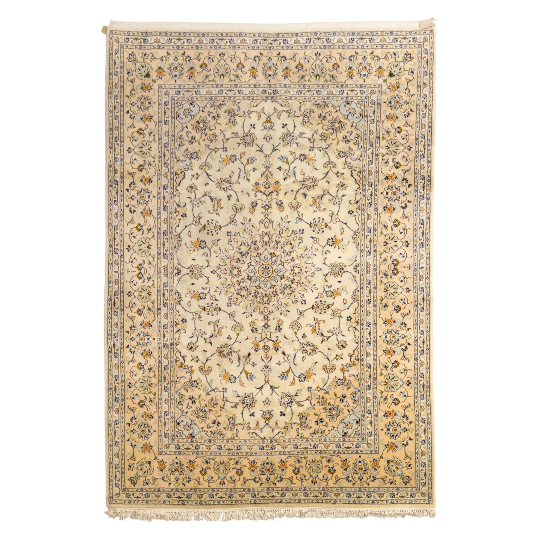 Central Persian Kashan hand-knotted carpet, ivory ground with central rosette medallion surrounded by scrolling floral vines and palmettes, field framed by a meander border flanked by multiple guard stripes, with cotton fringe end and a replaced fringe end