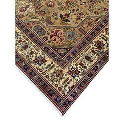 Persian Azarbaijan golden ground carpet, the shaped crimson ground medallion decorated with geometric motifs, the field profusely decorated with stylised plant and flower head motifs, repeating border with guard bands 