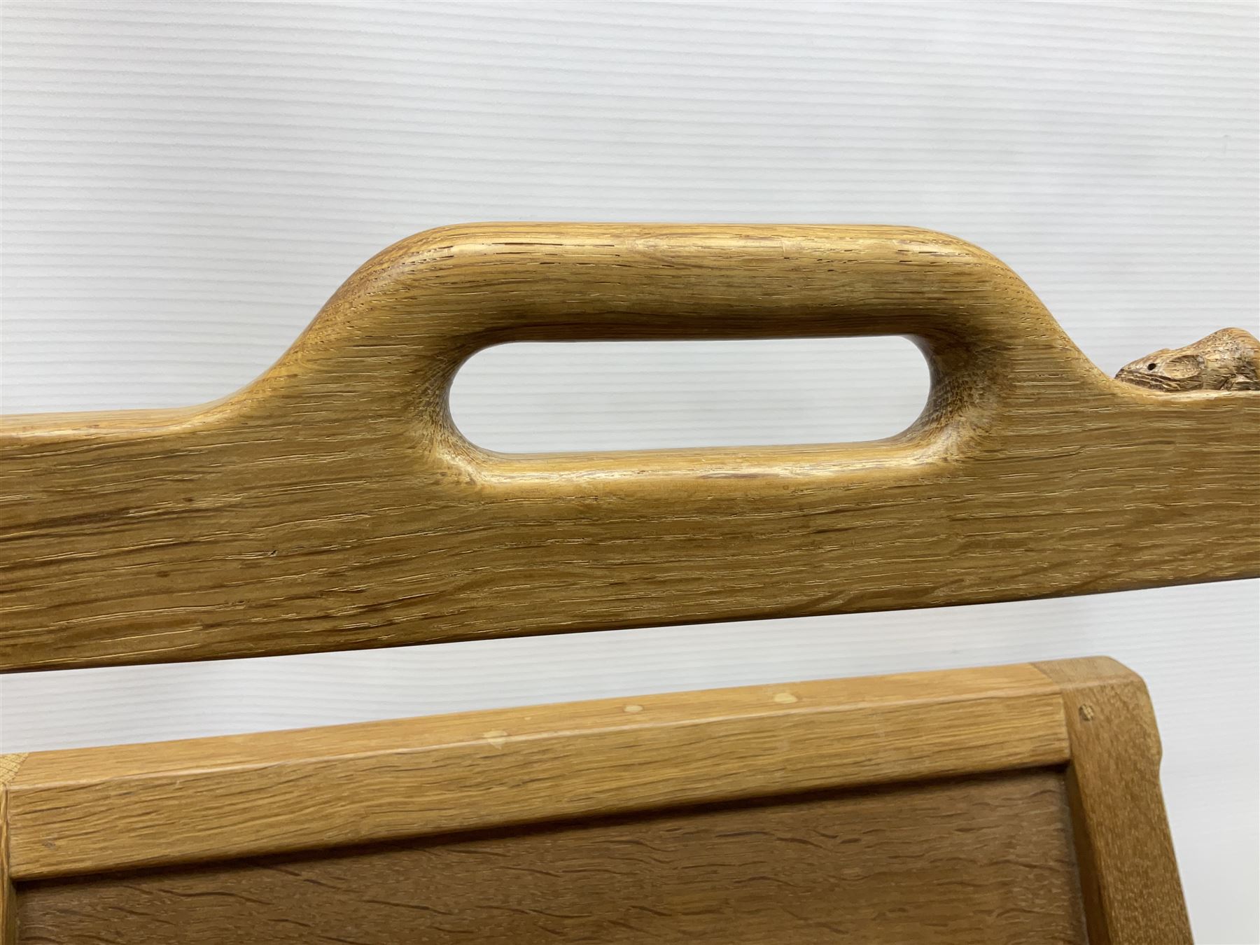 Mouseman - oak magazine rack, the top rail pierced with handle and carved with mouse signature, octagonal supports with two panelled and splayed sides, on sledge feet, by the workshop of Robert Thompson, Kilburn 