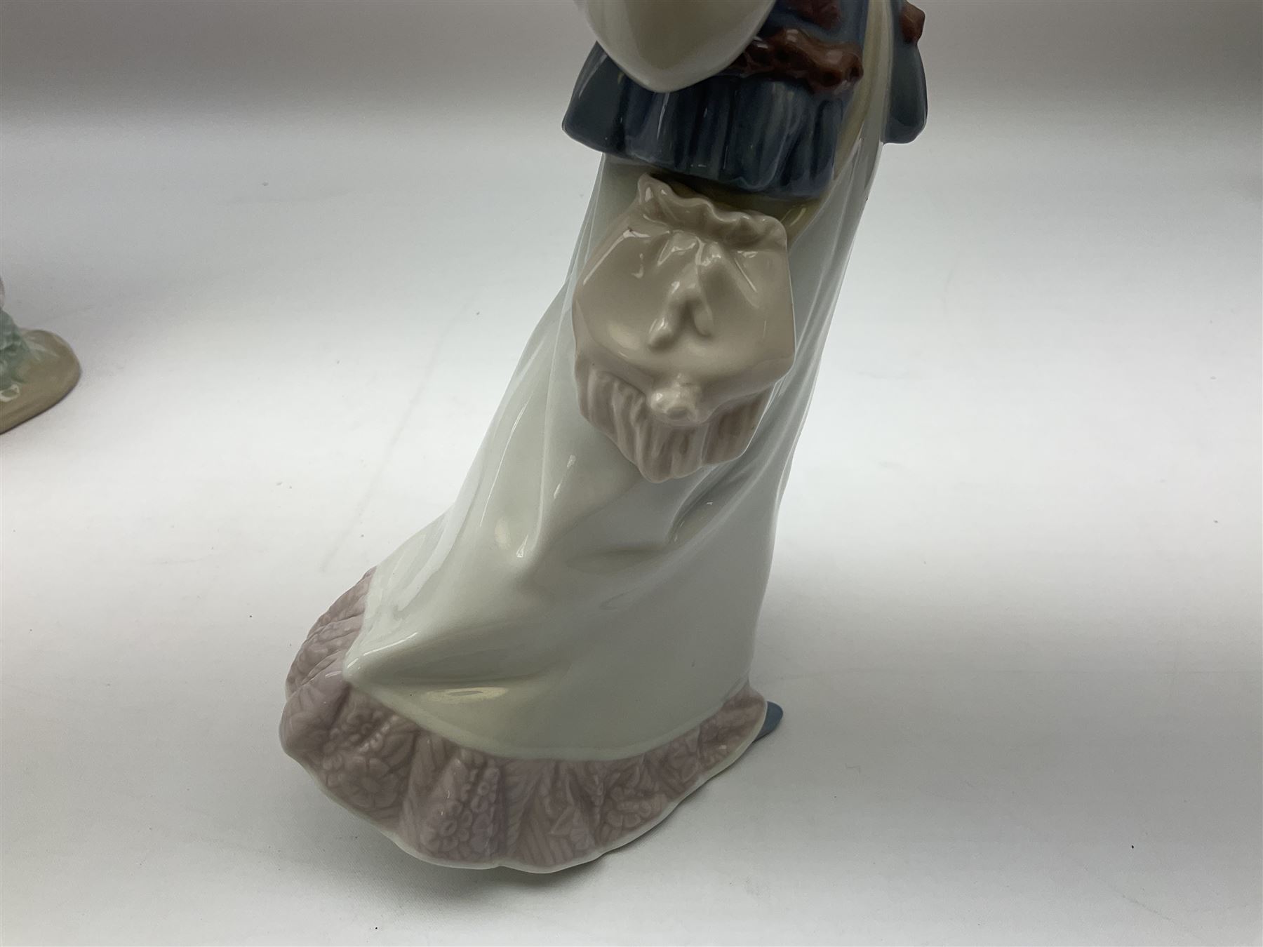 Three Lladro figures, comprising, Dreams of Summer Past no 6401, Spring Breeze no 4936 and Breezy Afternoon 5682 together with Lladro plaque Art Brings us Together no 7677, all in original boxes, largest example H35cm