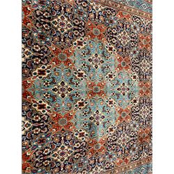Persian indigo and rust ground carpet, the field decorated with multiple shaped floral design panels with lighter blue ground central panels forming medallion, guarded border decorated with stylised plant motifs 