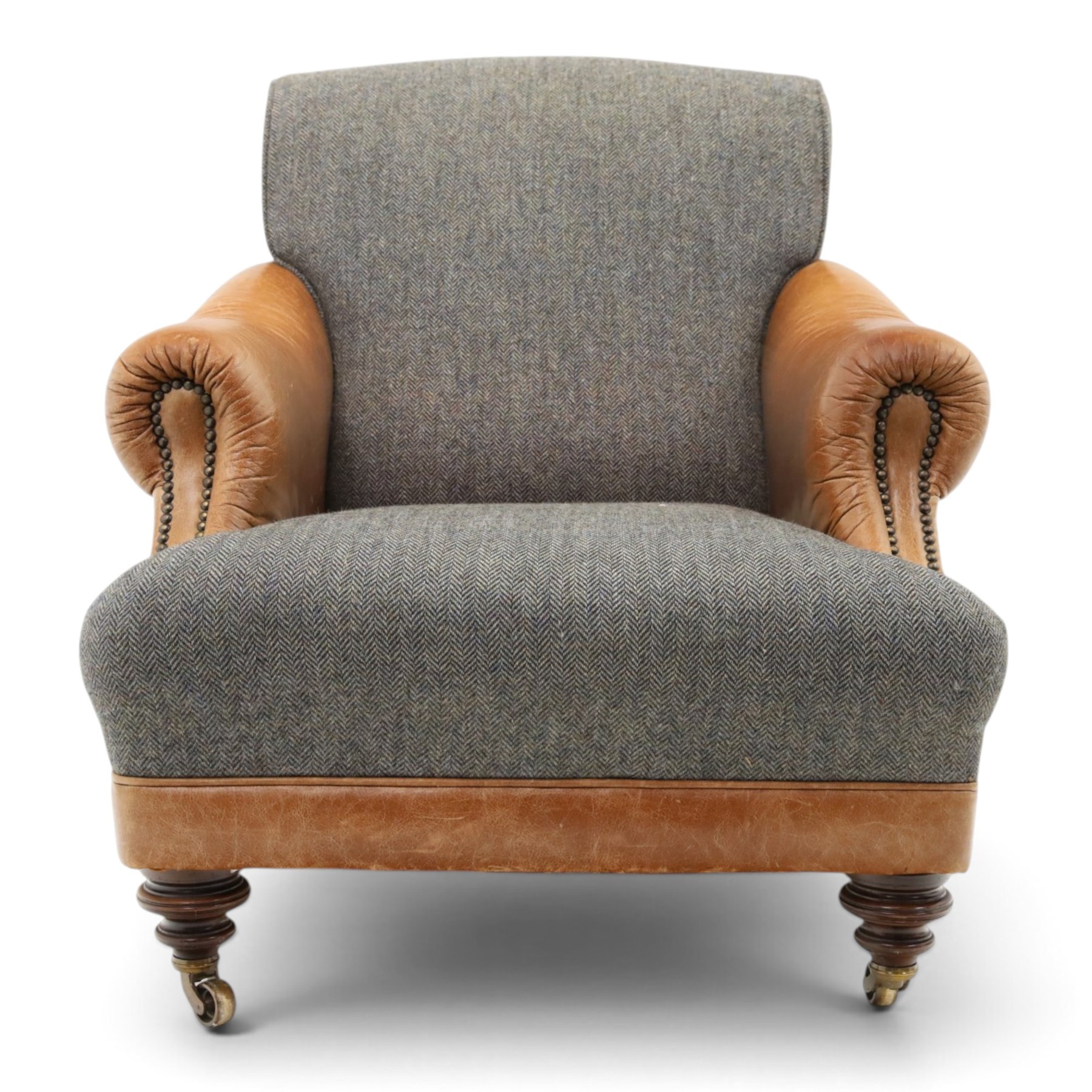 Tetrad - 'Taransay' Harris Tweed and tan leather club armchair, Howard shape with reclined back over deep seat and rolled arms with studwork, raised on turned front supports with castors, the sides and arms upholstered in tan leather with seat and back in herringbone-stitched Harris Tweed