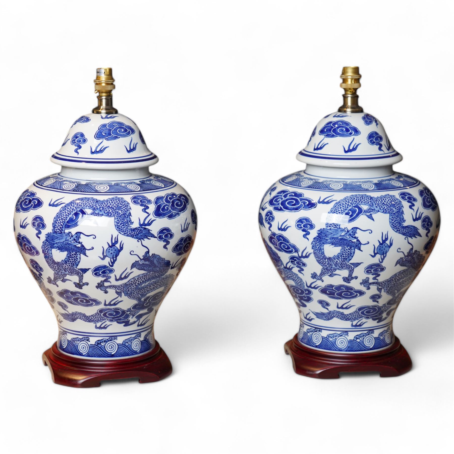 Pair of large table lamps of lidded baluster form, decorated with dragons chasing flaming pearls amongst clouds, on square footed base, H68cm including shades