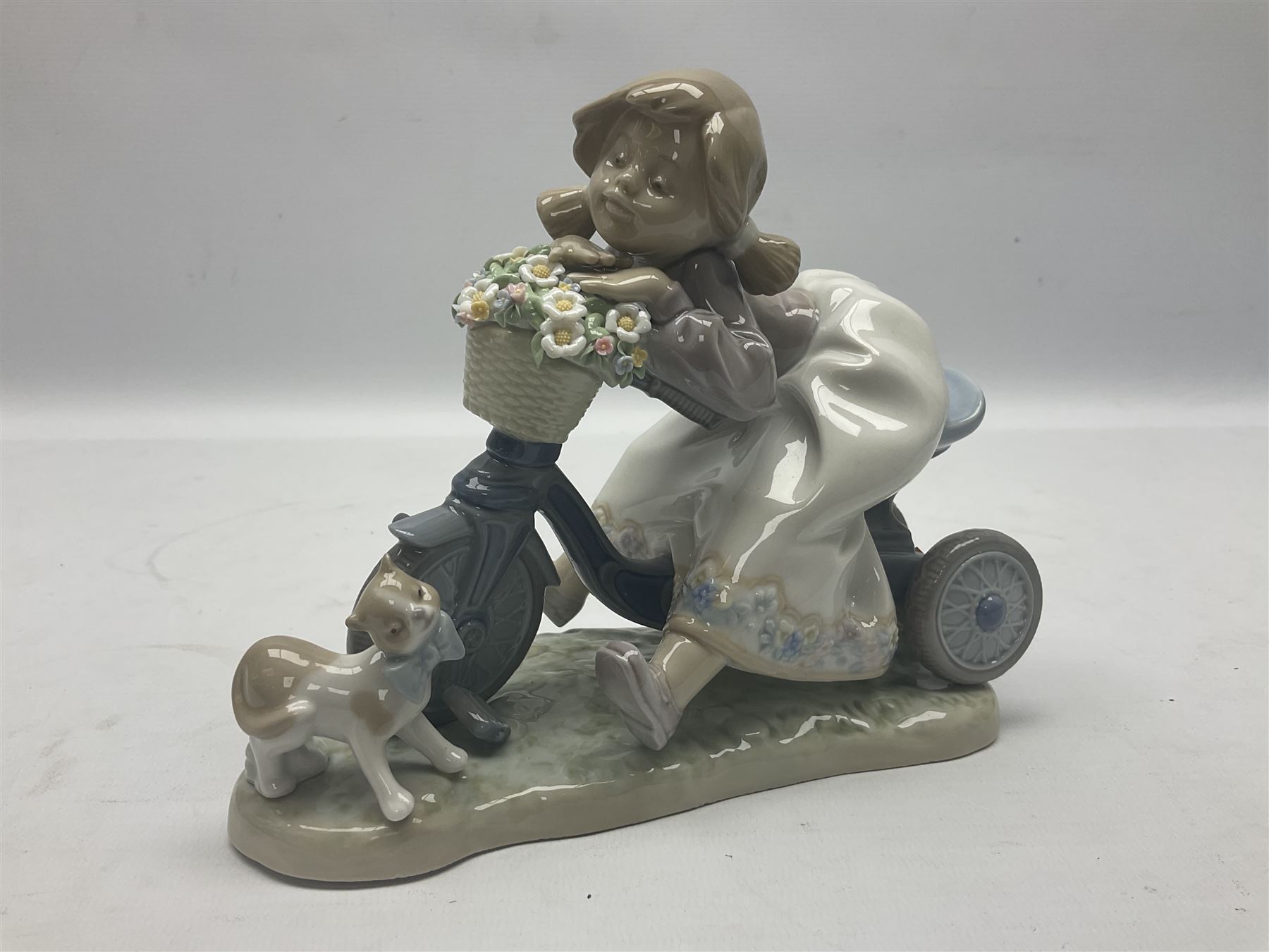 Lladro figure, In No Hurry, modelled as a girl on a tricycle, sculpted by Francisco Polope, with original box, no 5679, year issued 1990, year retired 1994, H15cm