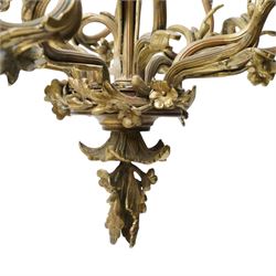 Rococo design brass ten light chandelier with scroll branches and ceramic candle holders H74cm