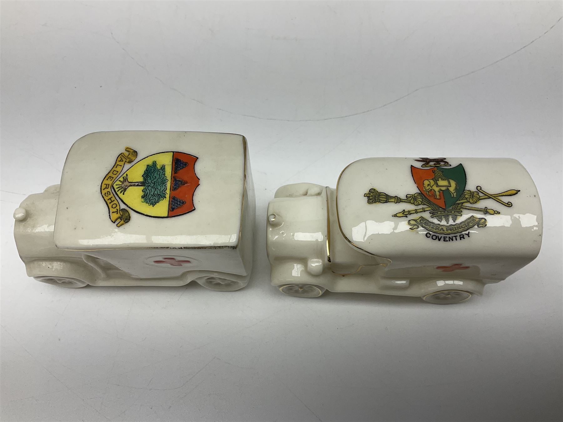 Ten WW1 crested china military models comprising seven field ambulances and three 'Home Fires Burning' fire-surrounds/range; various makers including Willow Art, Arcadian China, Grafton China, Savoy China, Carlton China etc; various crests including Devon, Aldershot, Portsmouth, West Ham, Coventry, Oxford, Hastings, Brighton etc (10)
