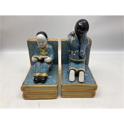 Pair of 20th century Chinese figural bookends, modelled as children in traditional blue dress sat reading and kneeling upon stacks of books, H22cm