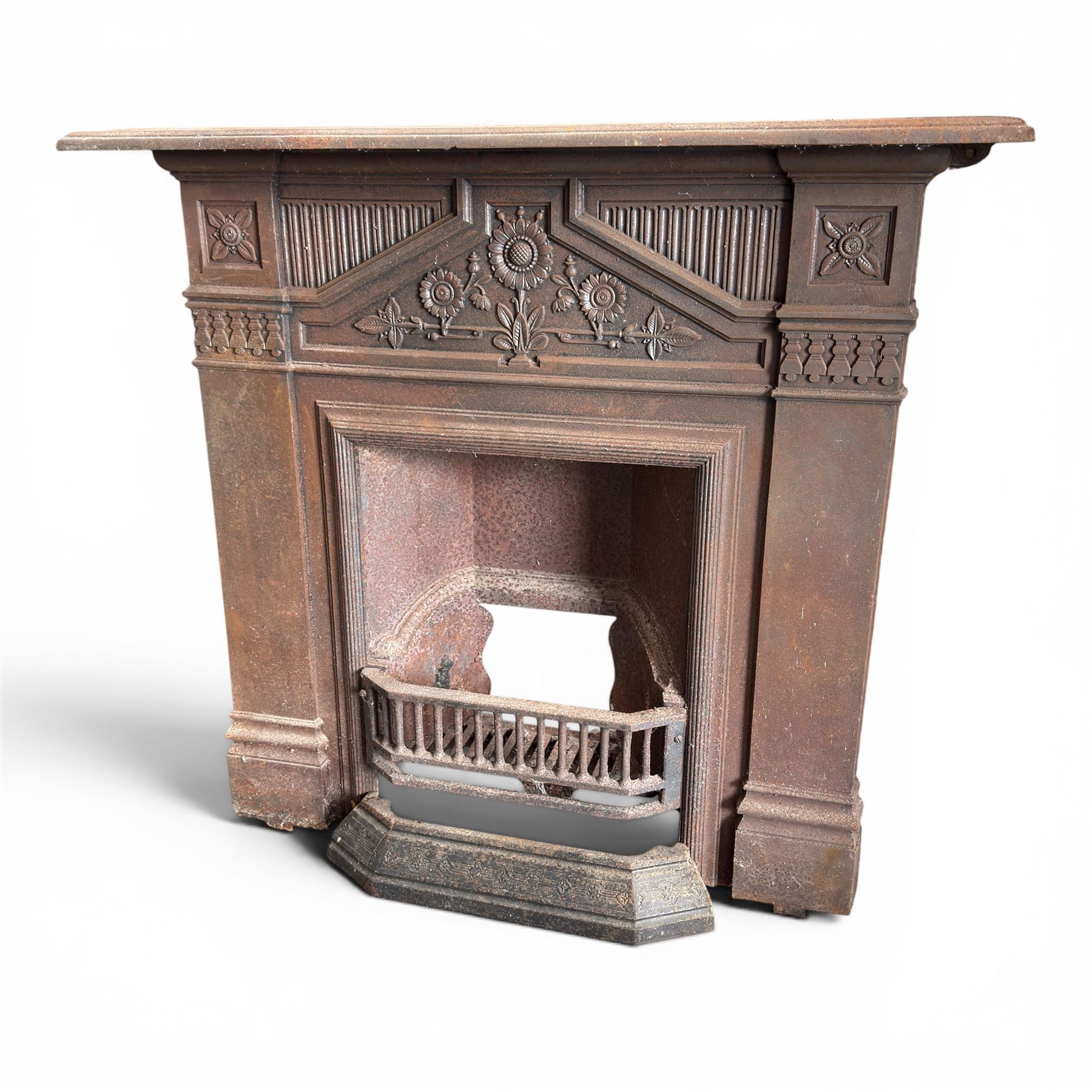 Late Victorian cast ion bedroom fireplace, decorated with floral poppy motifs and flluting