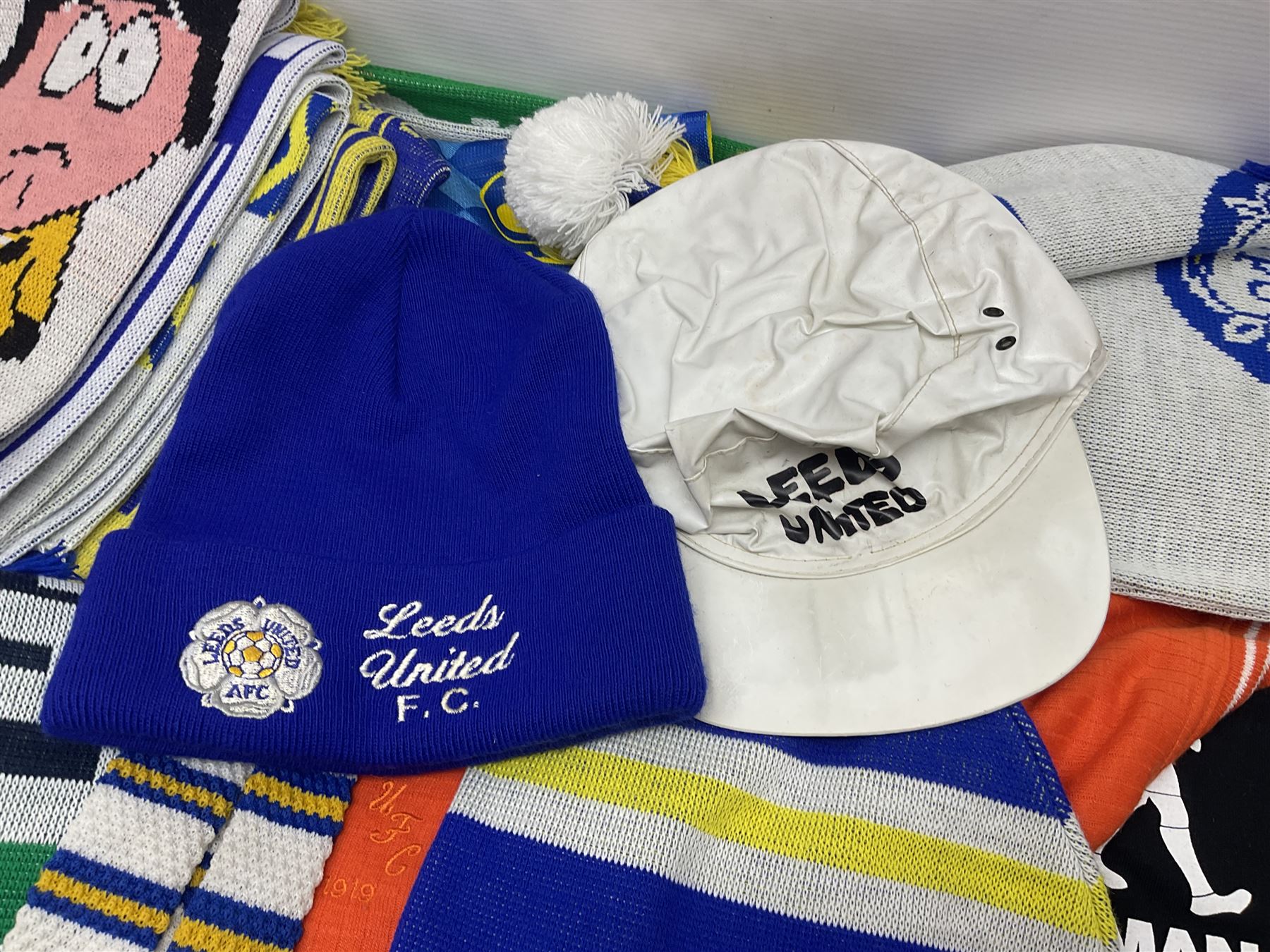 Collection of Leeds United scarves, hats and t-shirts, together with a Washington Redskins NFL sweatshirt and an Australian rugby league shirt