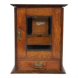 Oak smoking cabinet, with hinged lid, the glazed door opening to reveal a fitted interior,...