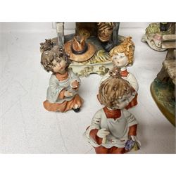 Group of Capodimonte figures, to include musical organ grinder with donkey and monkey, two tramp figures on benches, man with gun and choir boy and girl figures
