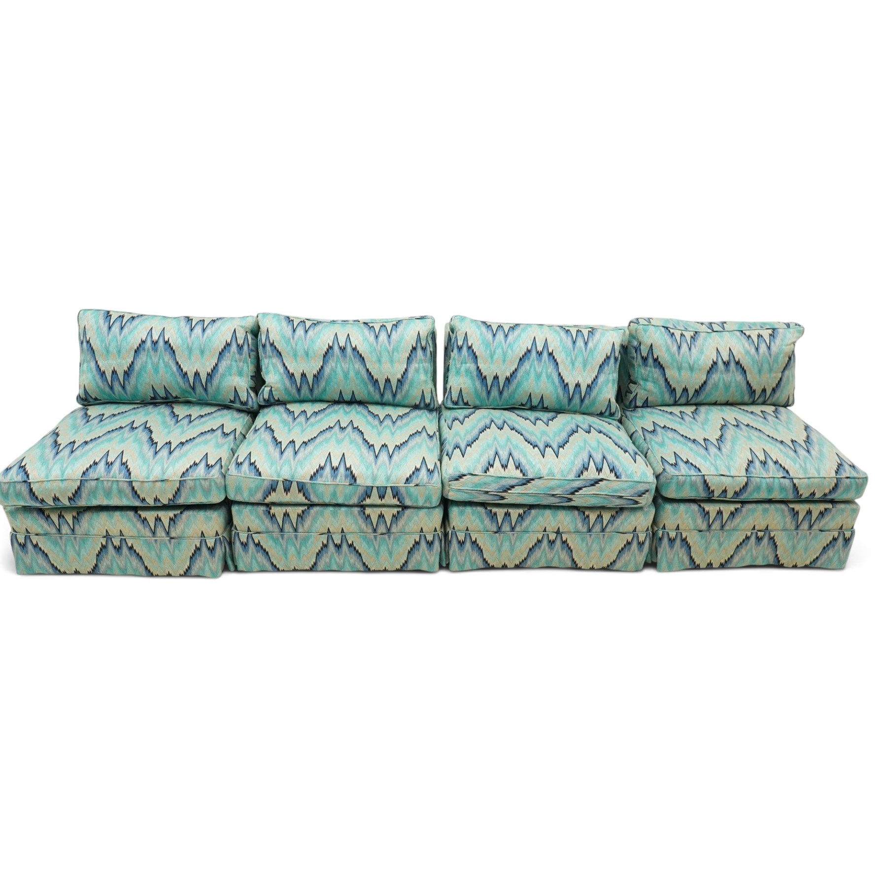 Parker & Farr - 1970s modular sofa suite comprising four chairs and footstool, reclined back with loose seat cushion, upholstered in turquoise flame-stich fabric with skirt, on castors