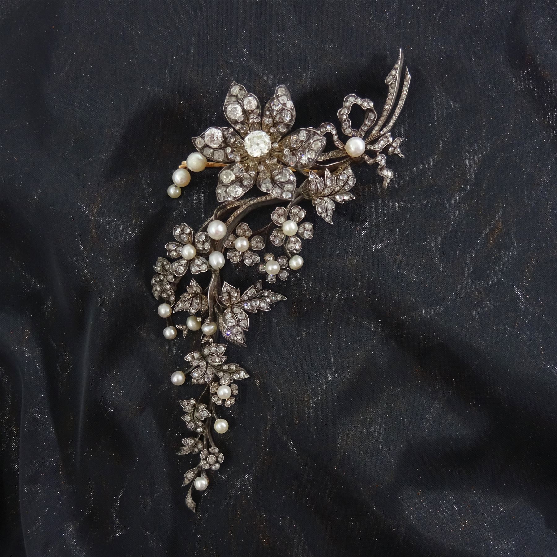 19th century gold and silver diamond and pearl en tremblant detachable brooch, the flower tremblant with a principal old cut diamond of approx 1.90 carat, the petals and stamen set with old cut and rose cut diamonds, total diamond weight approx 9.10 carat, to a foliate spray set set with further rose cut diamond and white / pink / cream pearls and ribbon tie
