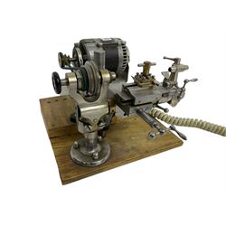 Lorch 6mm watchmakers lathe with tailstock, crosslide, tool rest, four-way tool post, pulleys and motor. Mounted on a wooden board.