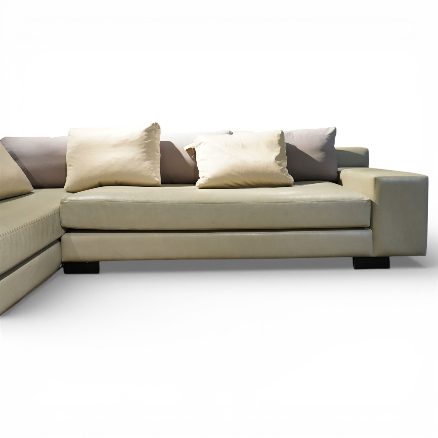 Christian Liaigre (1943-2020) - 'Arpege' handmade L-shaped sectional sofa, upholstered in neutral leather, with broad squared arms, deep seat cushions, angled chaise section, loose back cushions, raised on block feet