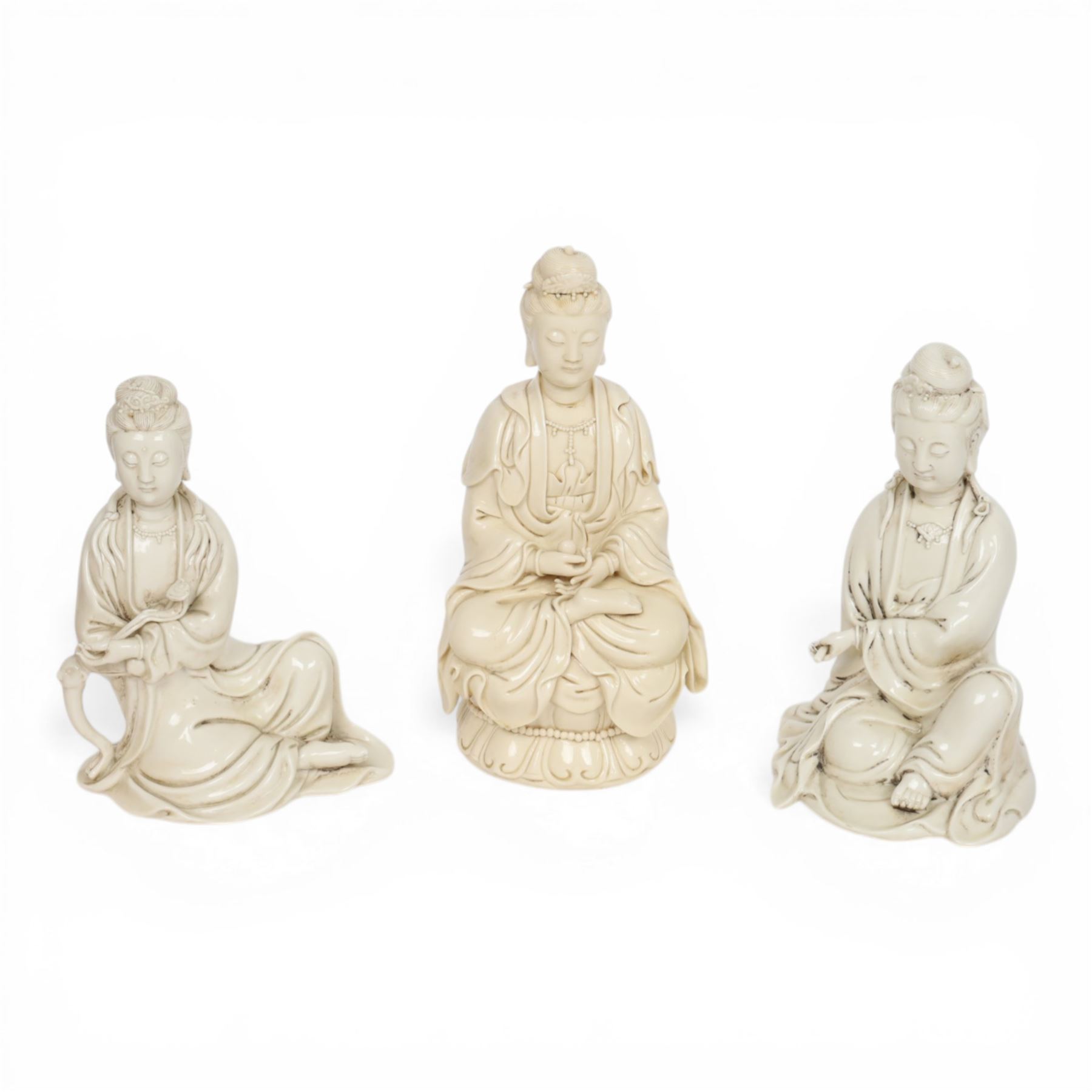 Three Chinese blanc de chine, each depicting Guanyin seated, Dehua province, two with double gourd and potters seal marks to the reverse 