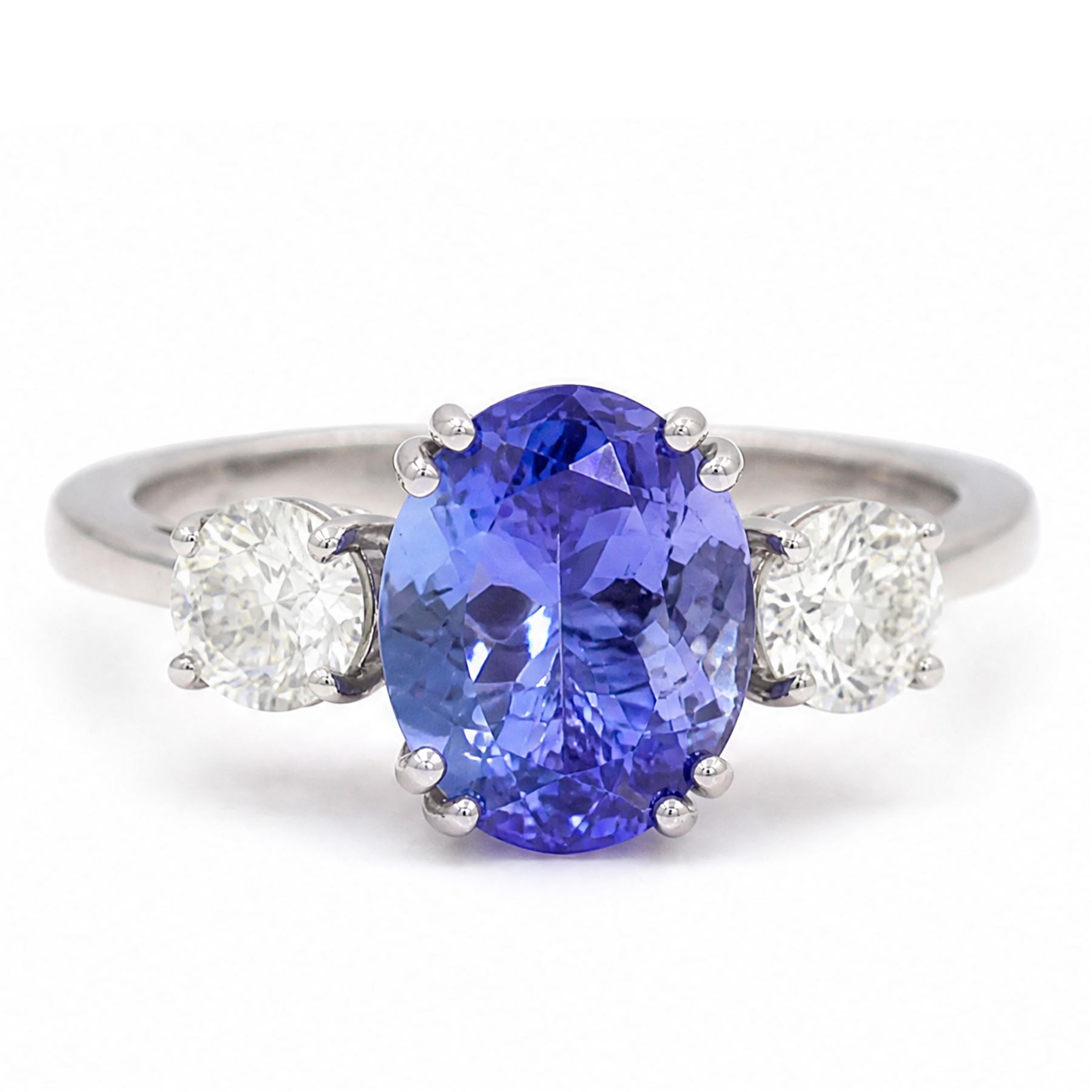 Platinum tanzanite and diamond three stone ring, single oval cut tanzanite of approx 3.55 carat, with a round brilliant cut diamond set either side, total diamond weight approx 0.80 carat