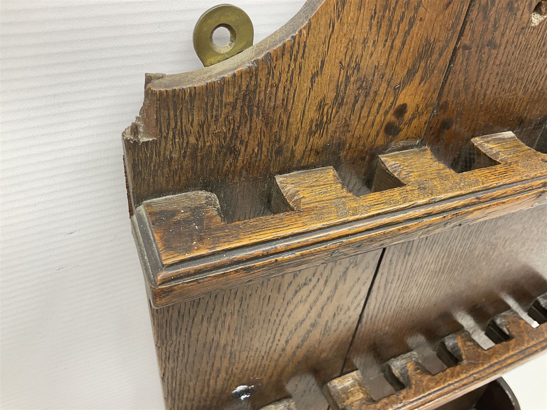 George III oak spoon rack and candle box, the rectangular backplate with shaped  pediment and two six aperture spoon racks, above a candlebox with hinged cover, with various brass spoons and a pair of brass candle snuffers, H56.5cm, W35cm, D14cm 