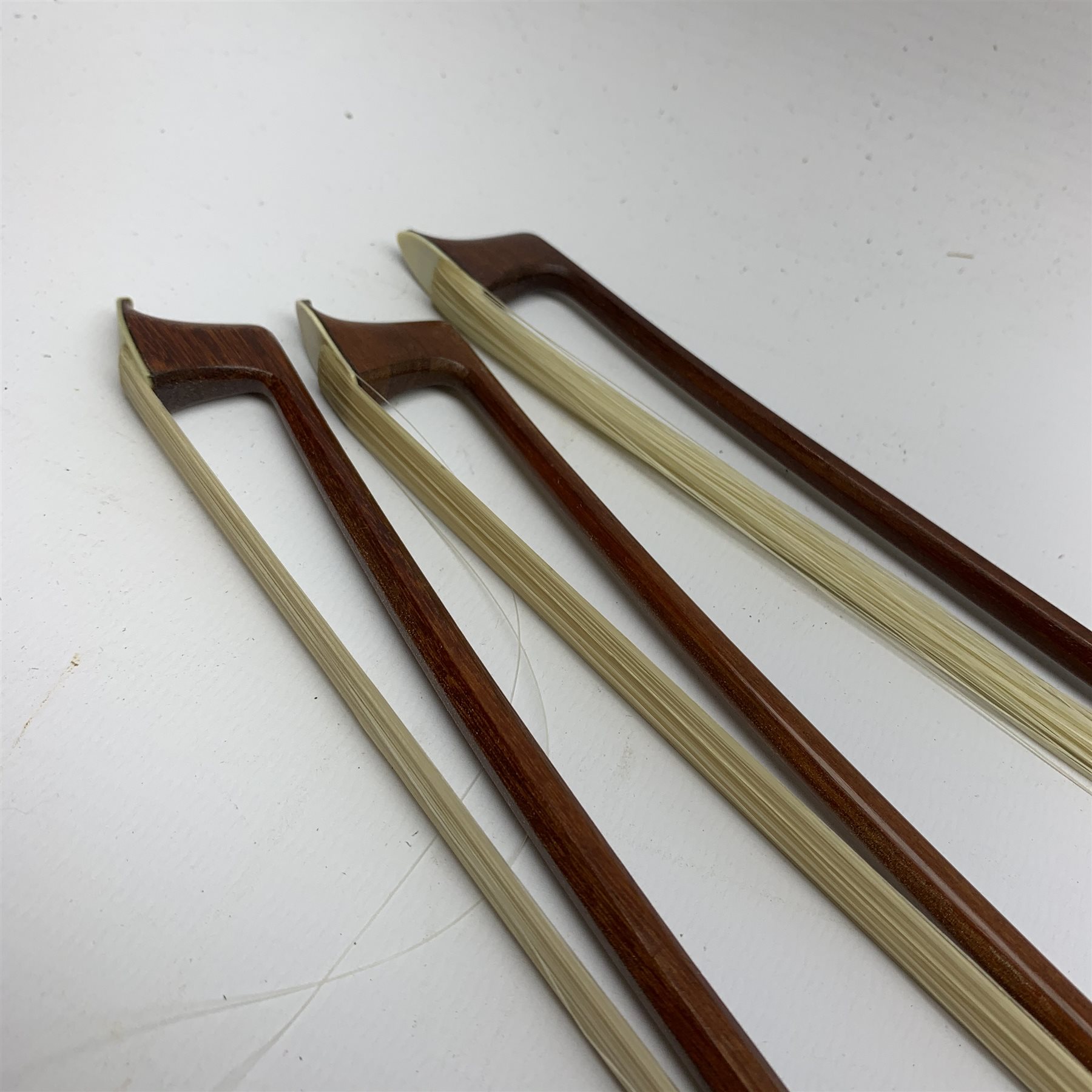 Three pernambuco bows by F.C. Pfretzschner with silver mounts, Adolf Thoma and Tourte