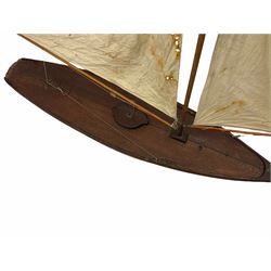 Large Victorian pond yacht, the planked hardwood hull with large lead weighted keel and working rudder, simulated planked deck and single mast with original sails; on later scratch-built wooden stand L117cm H151cm