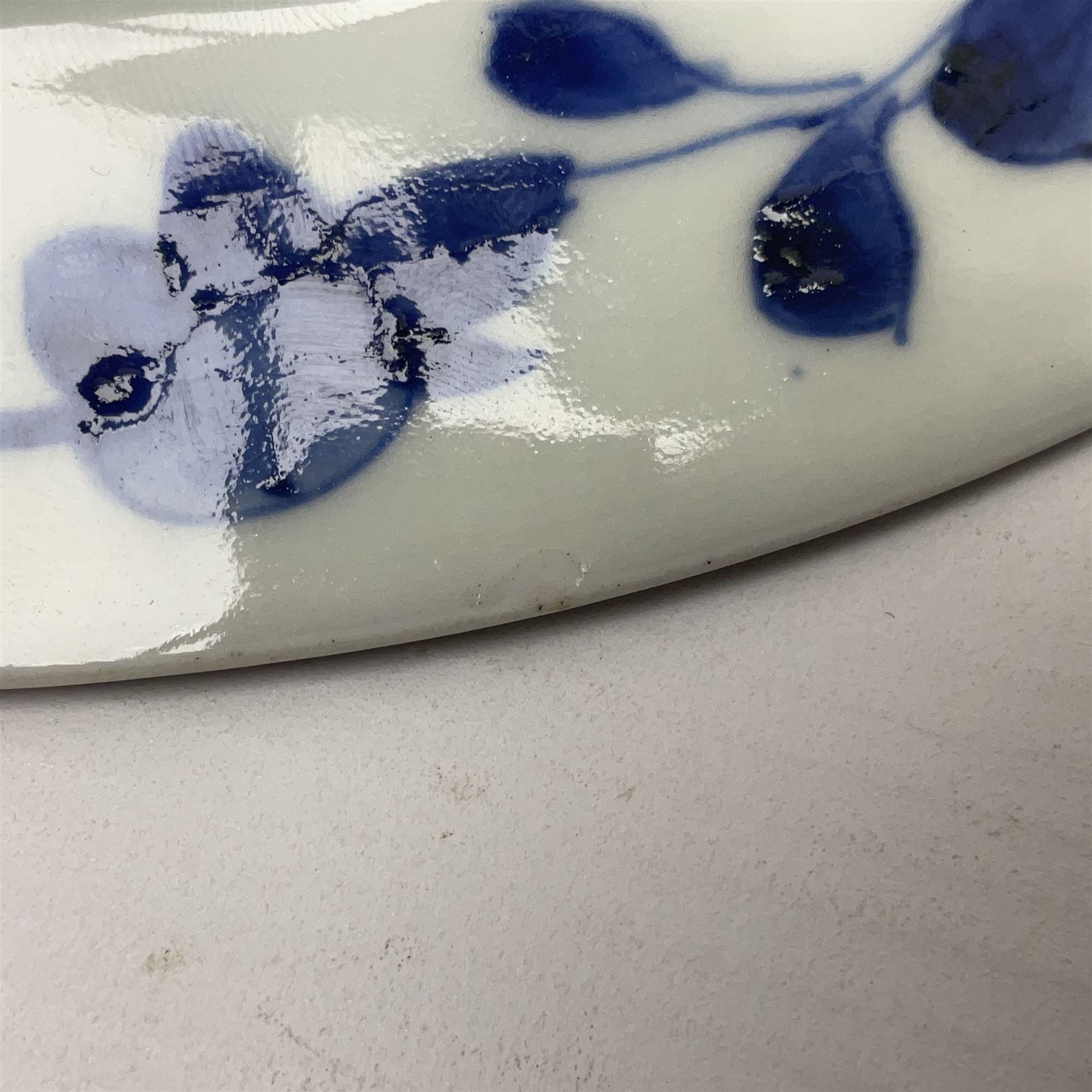 Japanese Meiji period Arita blue and white plate, of circular form, painted with riverside landscape and bird upon flowering branch, with character mark beneath, D24.5cm, together with two 18th century Chinese blue and white plates, each painted with floral design, each approximately D22.5cm