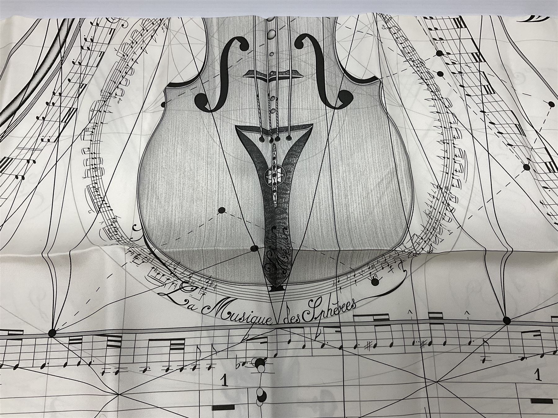 Hermès 'La Musique Des Spheres' silk scarf, designed by Zoe Pauwels in 1996, printed with a Viola Medici surrounded by musical motifs in black, on ivory white ground, with rolled hand stitched edges and Hermes material label, 87cm square