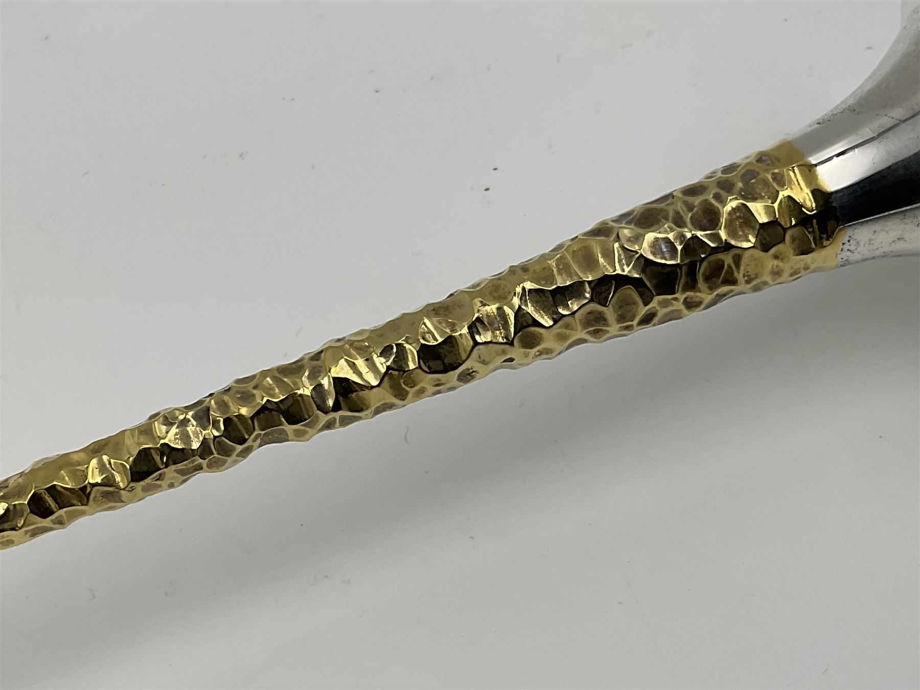 Pair of modern silver candlesticks by Stuart Devlin, the tapering parcel gilt stems with signature textured detailing, each supporting a fluted candle holder and upon a spreading circular foot, hallmarked Stuart Devlin, London 1973, H25cm