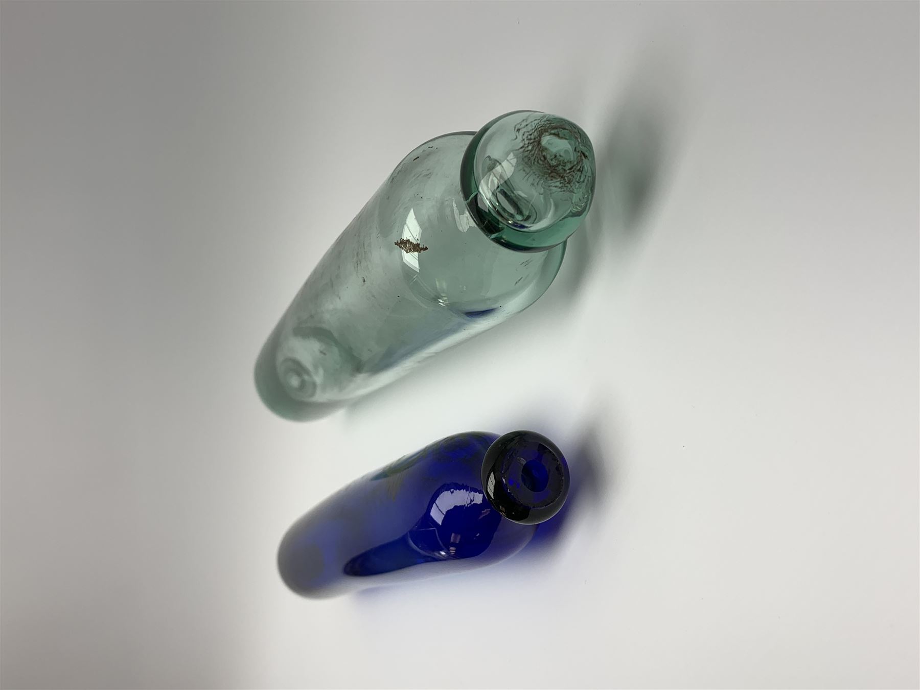 19th century Bristol blue glass rolling pin, with printed and gilt decoration of a schooner, crossed union flags, and inscription 'I wish you well', L36cm, together with another 19th century green glass example, L39cm