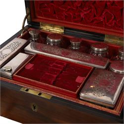 Victorian brass inlaid rosewood dressing table box, retailed by F.L. Hausburg, Liverpool, the lid centred by a brass cartouche, opening to reveal letter store to lid underside, above a fitted interior, with ten mounted cut glass jars, bottles and manicure set, within lift out leather trays, above jewellery drawer, with key, H17cm D24cm