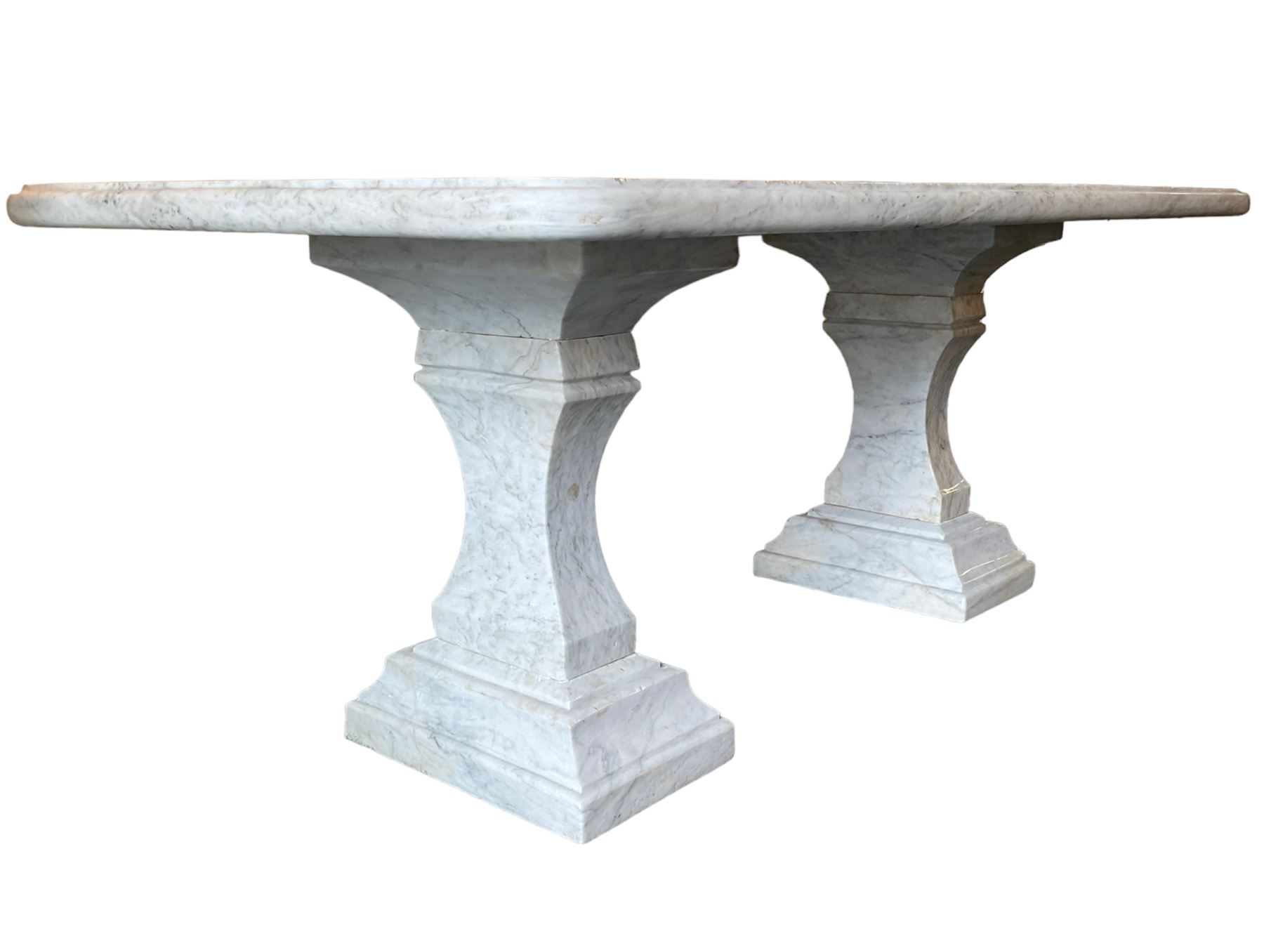 Classical Grecian design Carrera marble centre table, the rectangular single slab top with rounded corners and carved edge, raised on twin pedestals comprised of three pieces with a waisted column on a stepped plinth