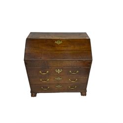 George III oak bureau, the fall front enclosing stepped pigeons holes drawers and sunken well with sliding lid, fitted with three long drawers, on foliage carved s-scroll feet