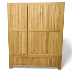 Modern light oak triple wardrobe,  three panel doors with integrated handles enclosing full-height hanging rails, the lower section fitted with two flush-front drawers, square uprights